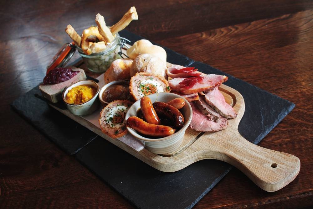 Sharing Platter At The Boars Head served on a paddle board with a variety of bar snacks